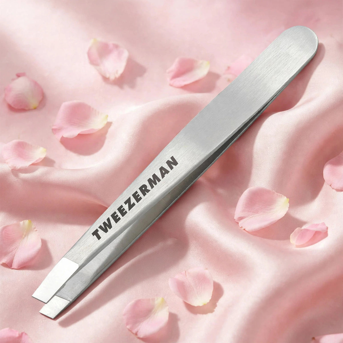 Tweezerman Classic Stainless Steel Slant Tweezer — product on blush-pink satin with rose petals