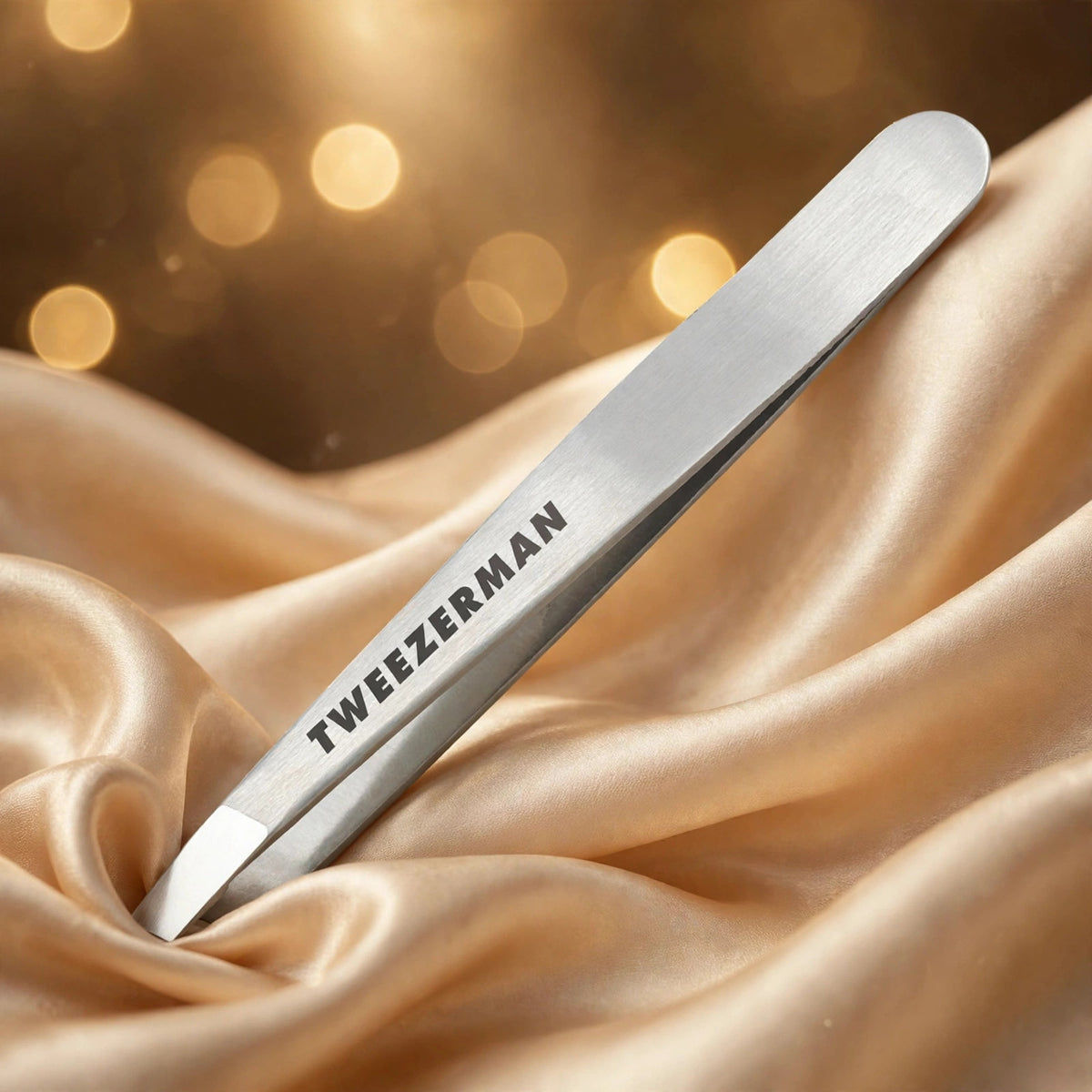 Tweezerman Classic Stainless Steel Slant Tweezer — product on champagne silk fabric