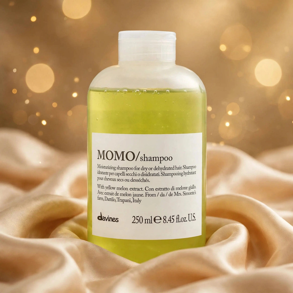 Davines MOMO Moisturizing Shampoo 250ml — product on champagne silk fabric
