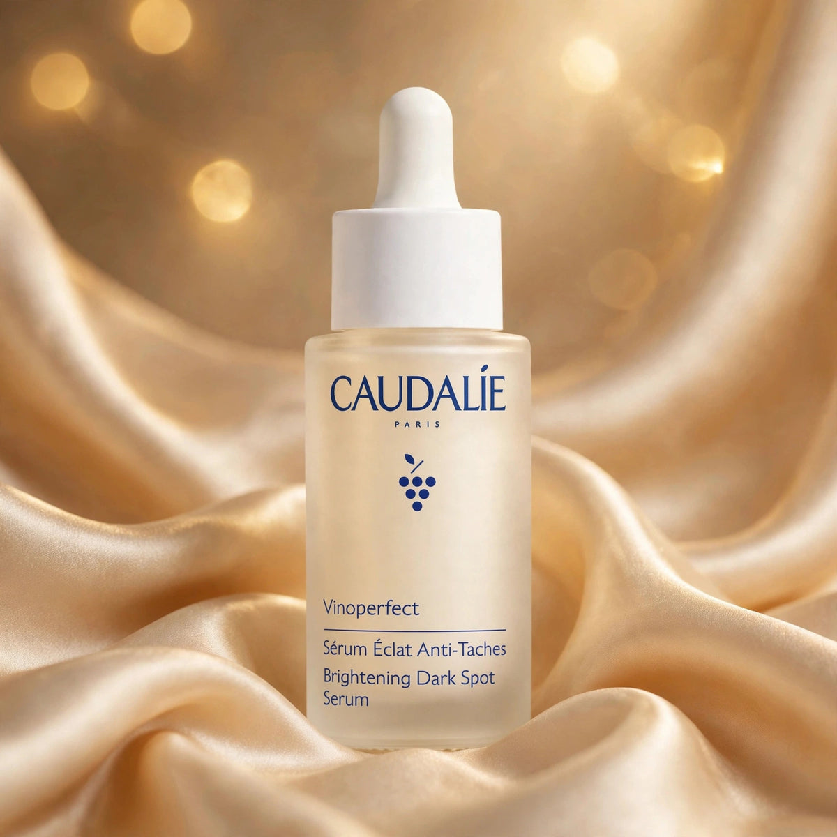 Caudalie Vinoperfect Brightening Dark Spot Serum 30ml — product on champagne silk fabric