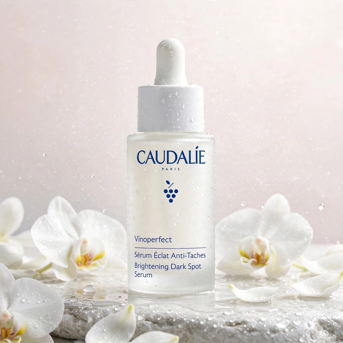 Caudalie Vinoperfect Brightening Dark Spot Serum 30ml — product with white orchids in spa setting