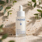 Caudalie Vinoperfect Brightening Dark Spot Serum 30ml — product on travertine stone with eucalyptus