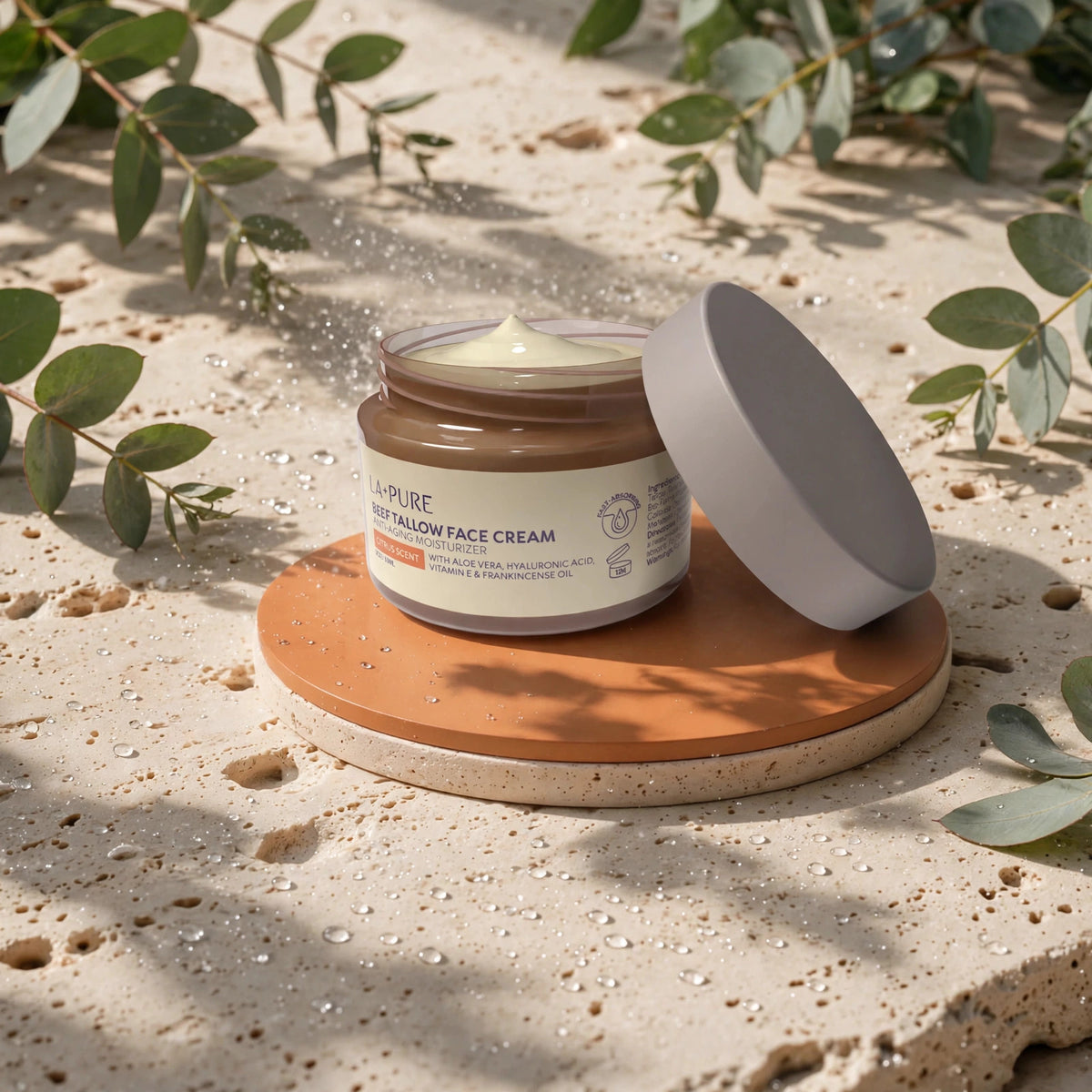 LA+ Pure Beef Tallow Face Cream 4oz — product on travertine stone with eucalyptus