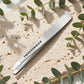 Tweezerman Classic Stainless Steel Slant Tweezer — product on travertine stone with eucalyptus